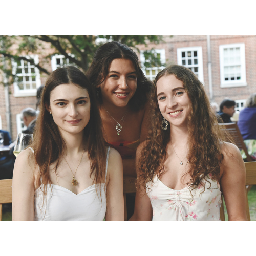 Three members smiling and wearing summer dresses in the Inn's gardens.